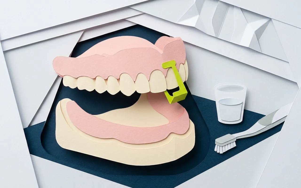 Protesi mobile totale appoggiata sul piano dello studio: quando serve l'adesivo dentiera e quanto